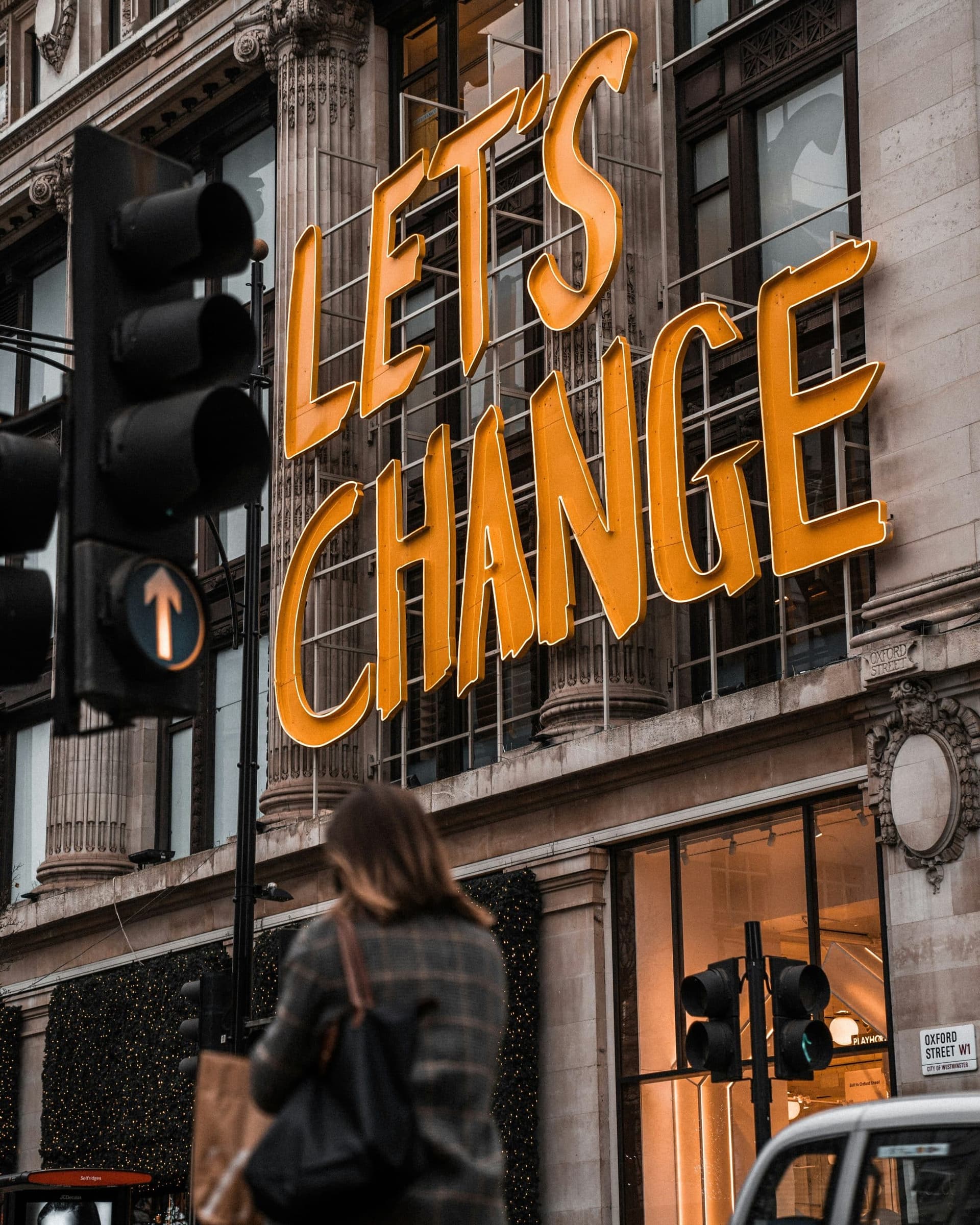 Street scene with a "Let's Change" sign, symbolising the shift agencies must make in response to AI
