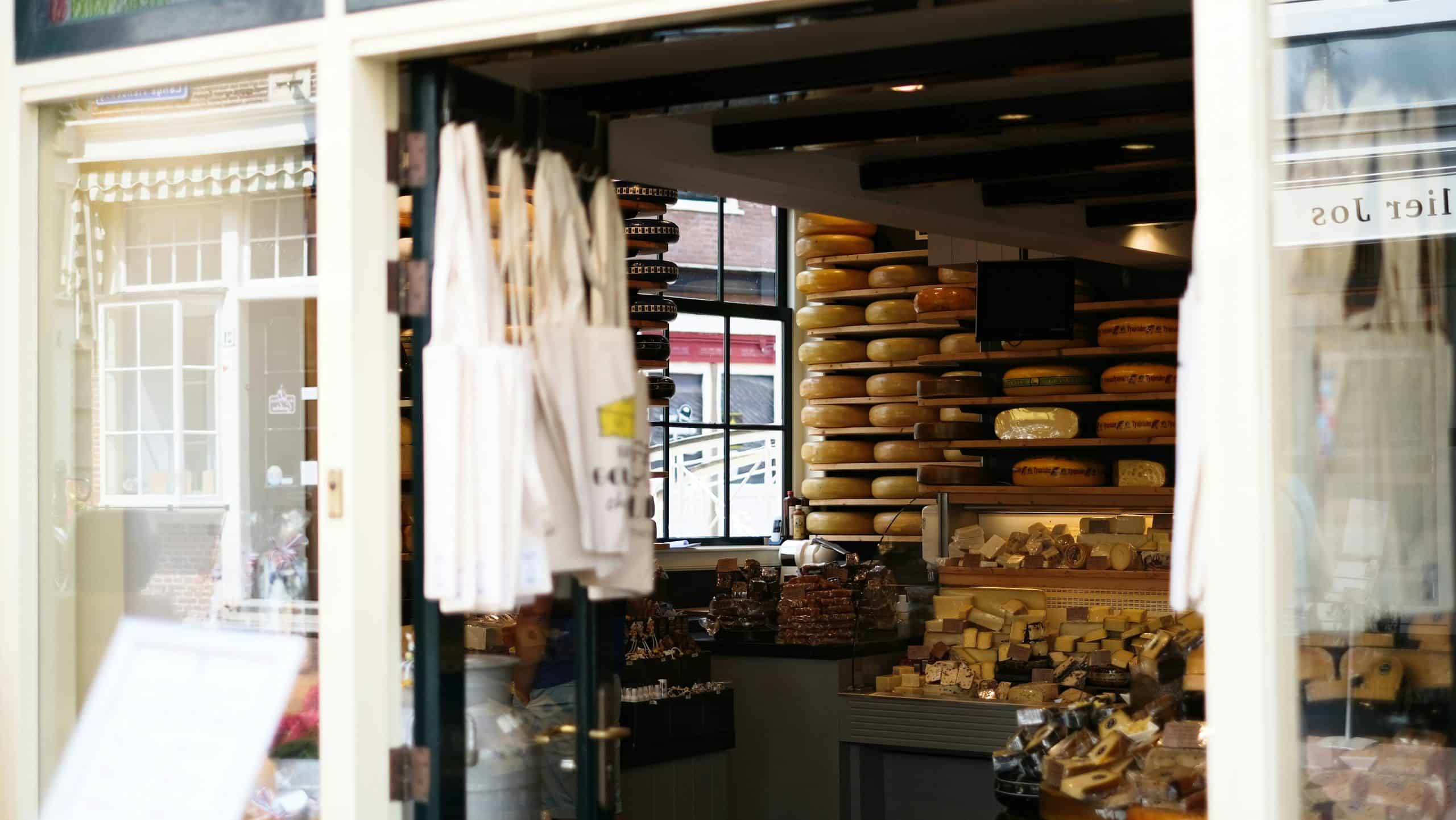 Open shop front with four closed umbrellas and shelves of products