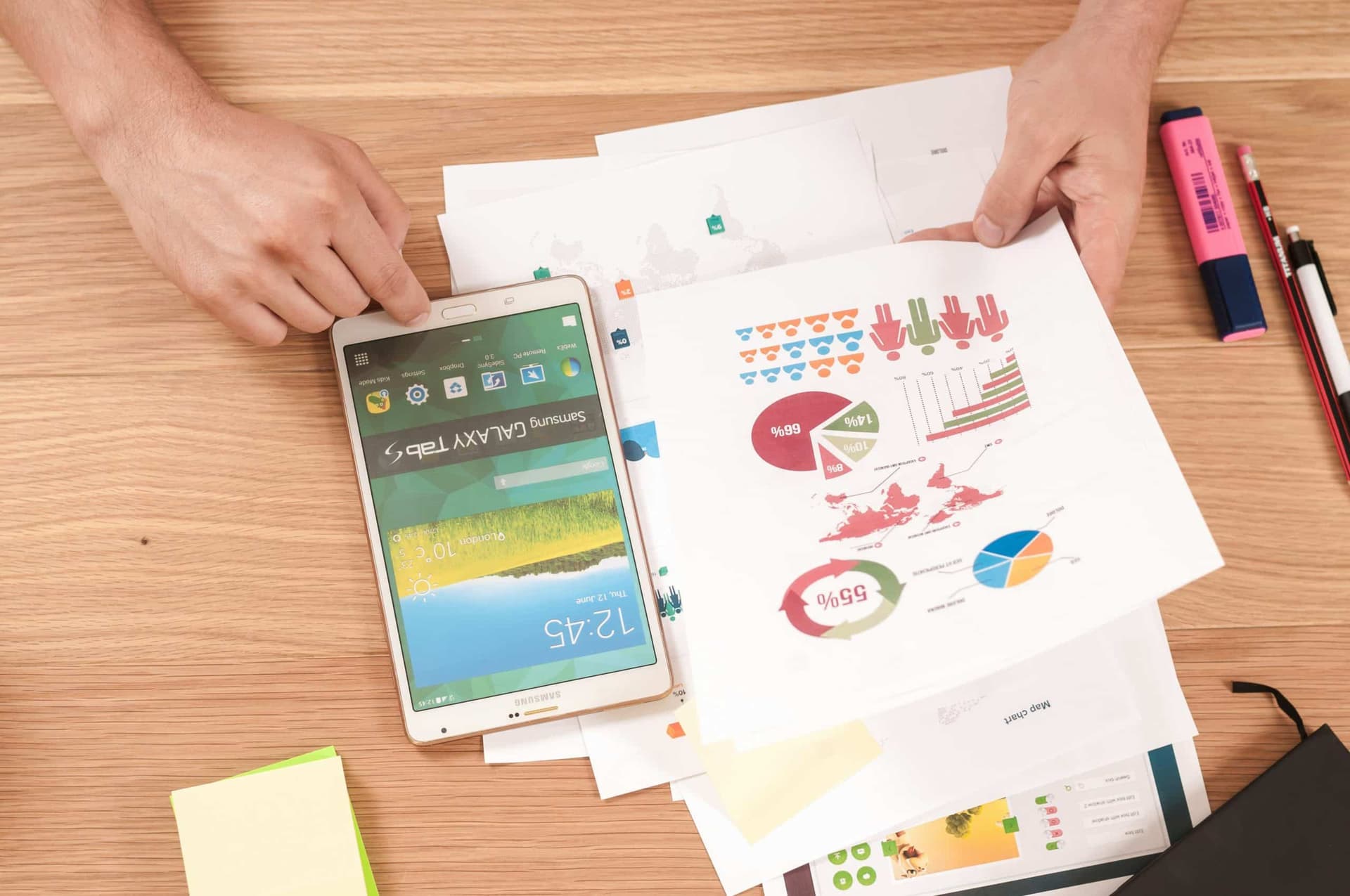 Papers lying on a table. Person viewing printed graphs and charts from business auditing SEO.